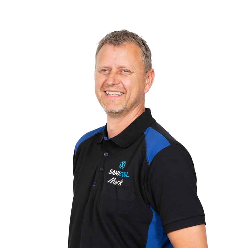 Professionele man in SaniCool werkshirt met naamlogo, lachend, witte achtergrond, representatief voor sanitaire en koeltechniek.